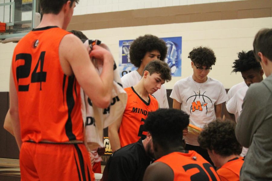 In 2019, the boys basketball team huddles during a tournament game against Joliet Central at the University of St. Francis. 